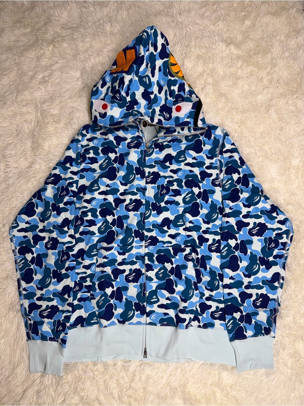 A Bathing Ape (BAPE) Gold Ape Head Tag - Light Blue Garment